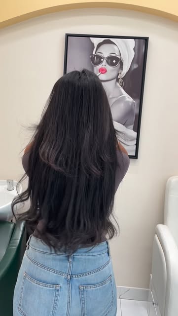 Sleek dark hair against the salon's cream arches